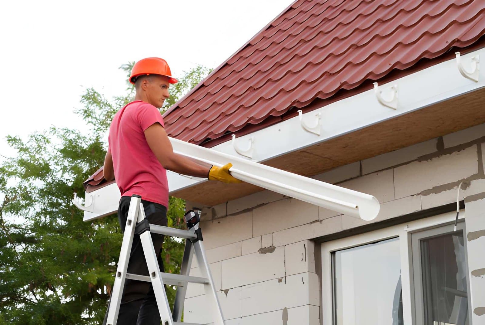 Installer fitting a new gutter run at the roof edge
