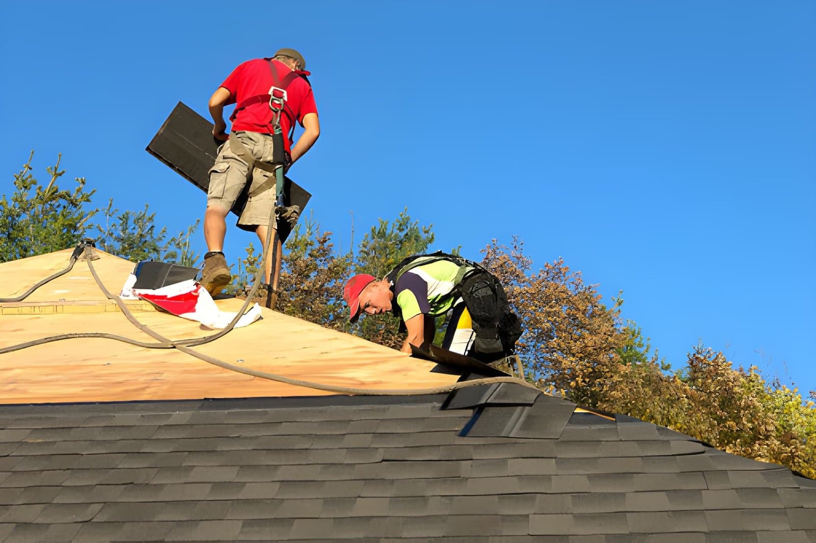 Crew installing new asphalt shingles during a roof replacement